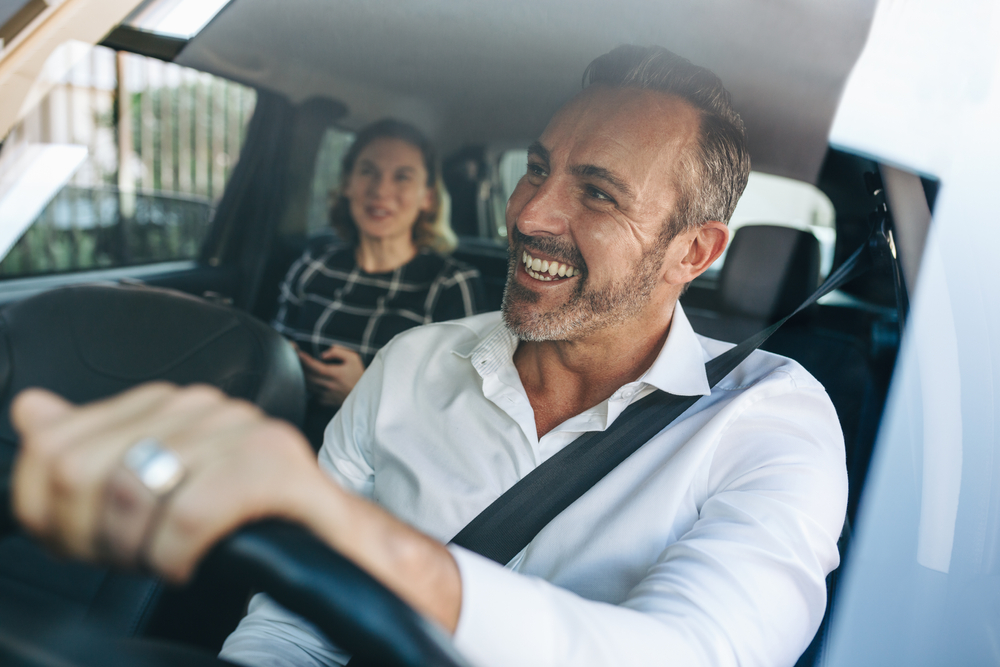 Taxi,Driver,Talking,To,A,Female,Passenger,Sitting,In,Backseat